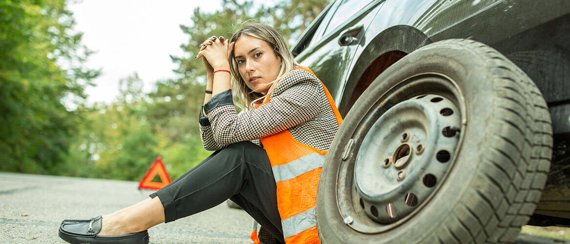 Mulher furo no pneu acidente à espera de assistência em viagem seguro auto